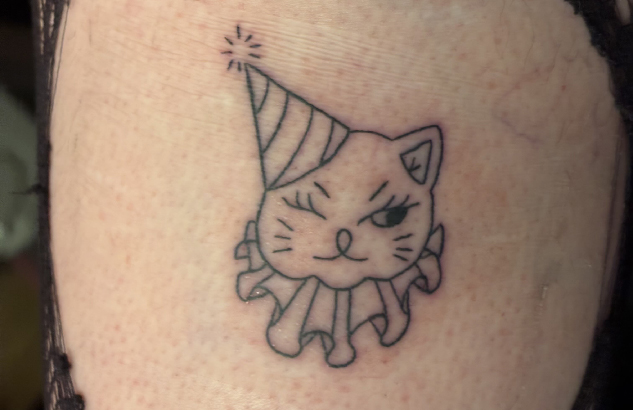 a ghost cat tattoo on a pale forearm.